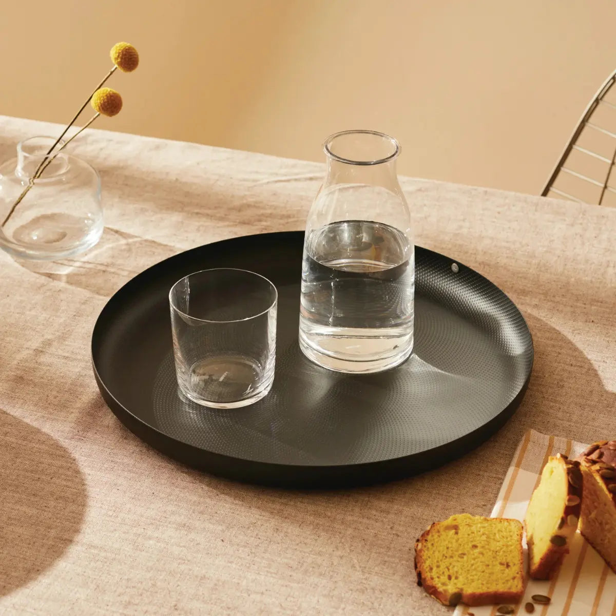 Vassoio da portata in acciaio nero con puntini a rilievo con bicchiere e brocca d'acqua