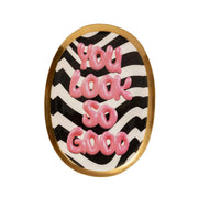 Vassoio svuotatasche con bordo dorato e scritta "you look so good" fucsia su sfondo bianco e nero a righe