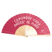 Ventaglio rosa con scritta bianca "Comunque vada andrò al mare". Sfondo bianco