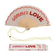 Ventaglio rosa con dettagli e scritta rossa "Summer love". Incluso il packaging e un laccetto per tenere il ventaglio al collo. Sfondo bianco