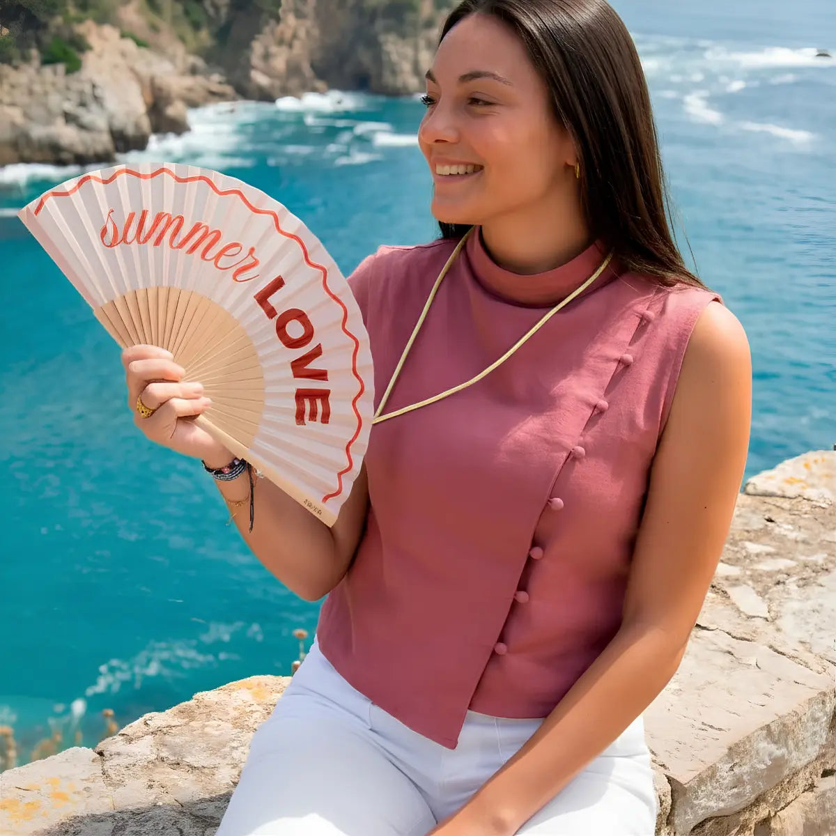 Donna che tiene in mano il ventaglio rosa con scritta rossa "Summer love"