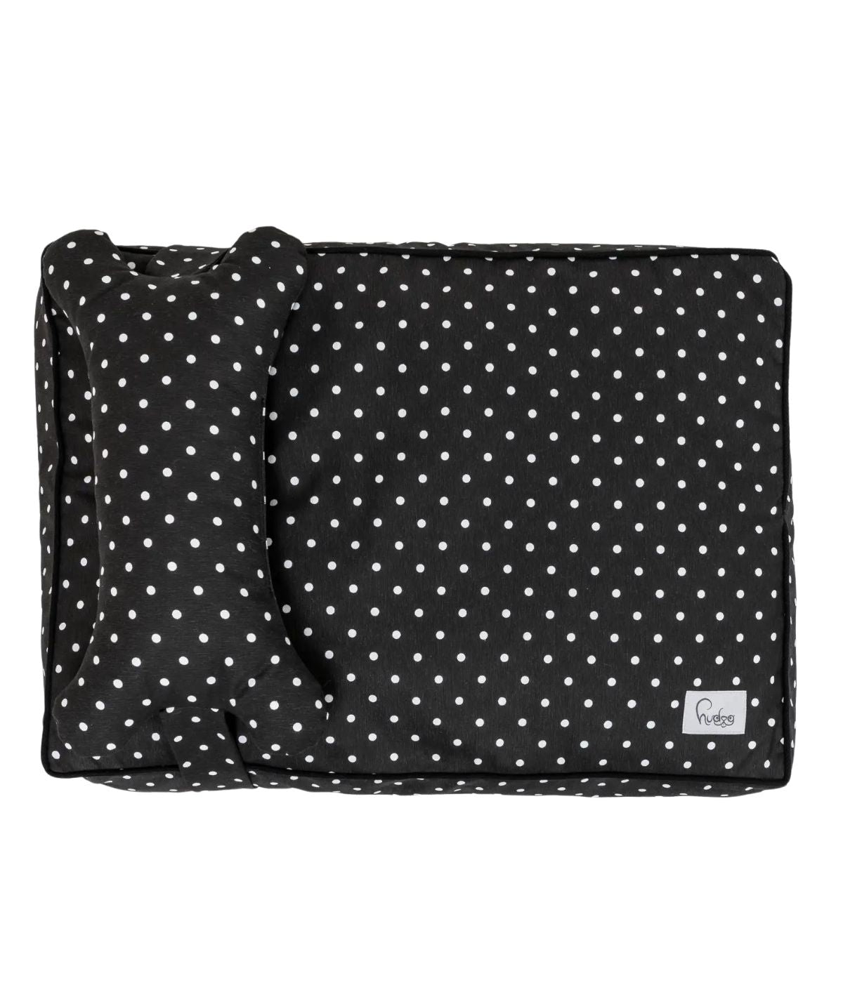 Cuccia letto per cani nero con pois bianchi e cuscino a forma di osso. Sfondo bianco