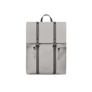 Vista frontale dello zaino con patta nella versione tortora. Materiale impermeabile, doppia cinghia per chiusura e tasche frontali. Sfondo bianco