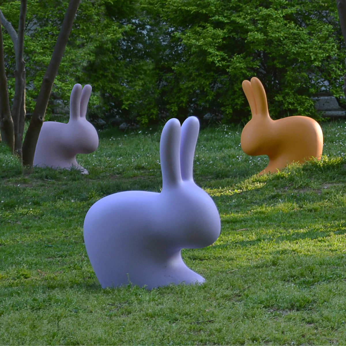 sedute rabbit qeeboo nei colori giallo e viola su prato verde