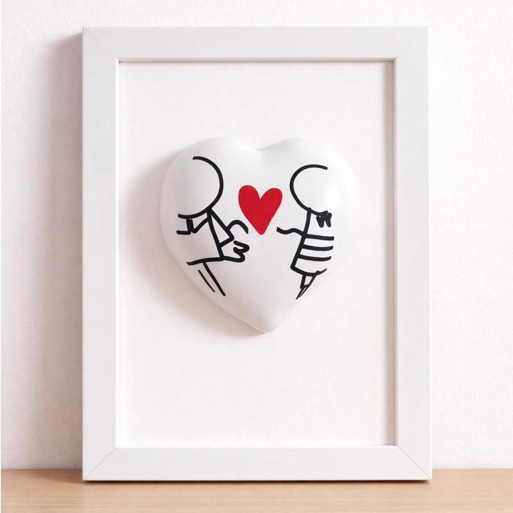 Quadretto CuoreAmore fatto a mano in Italia. Ha una cornice in legno bianca e un cuore in ceramica rosso con una scritta  