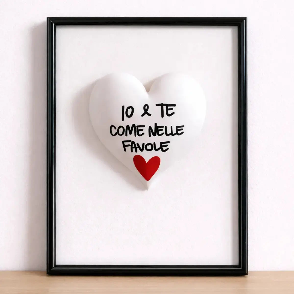 Quadretto CuoreAmore fatto a mano in Italia. Ha una cornice in legno bianca e un cuore in ceramica rosso con una scritta  