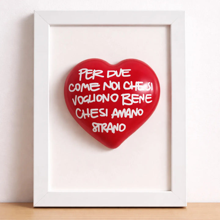 Quadretto CuoreAmore fatto a mano in Italia. Ha una cornice in legno bianca e un cuore in ceramica rosso con una scritta  